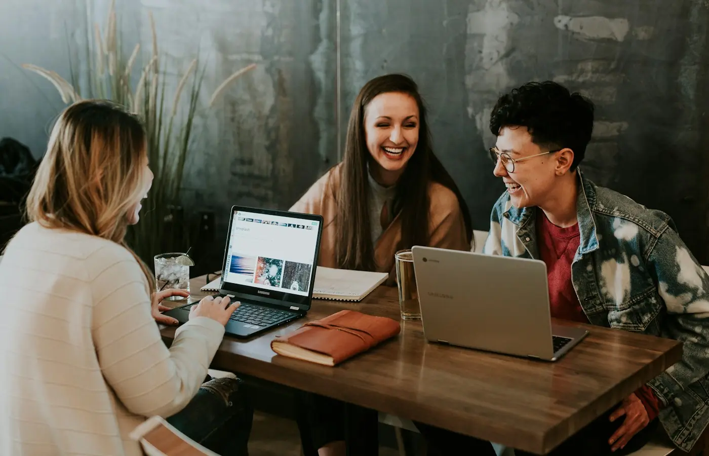 Tres compañeras trabajan juntas con sus portátiles